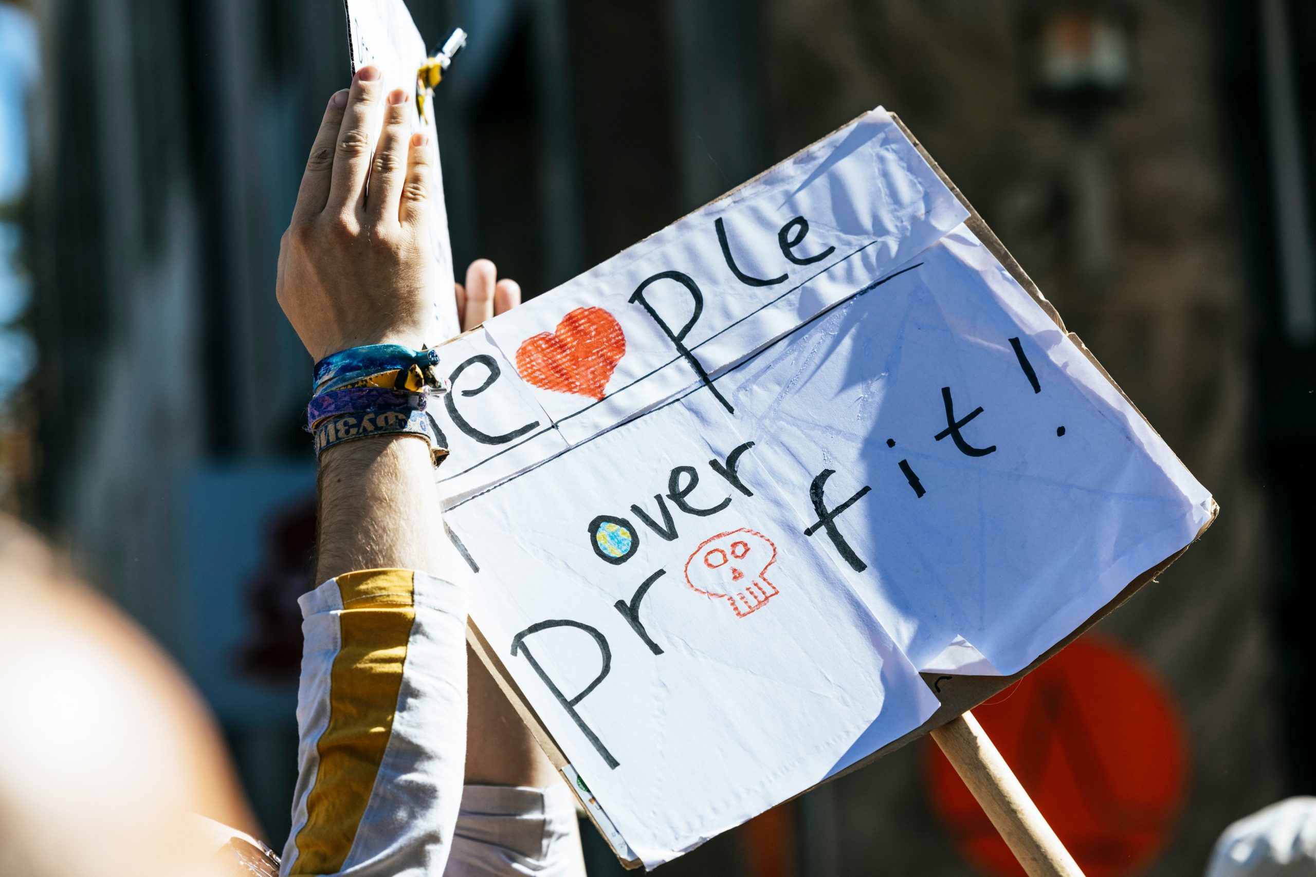 A protest sign reading “People over Profit” held up during a peaceful civic rally, representing Vision26’s call for integrity, compassion, and community-based leadership in Hamilton.