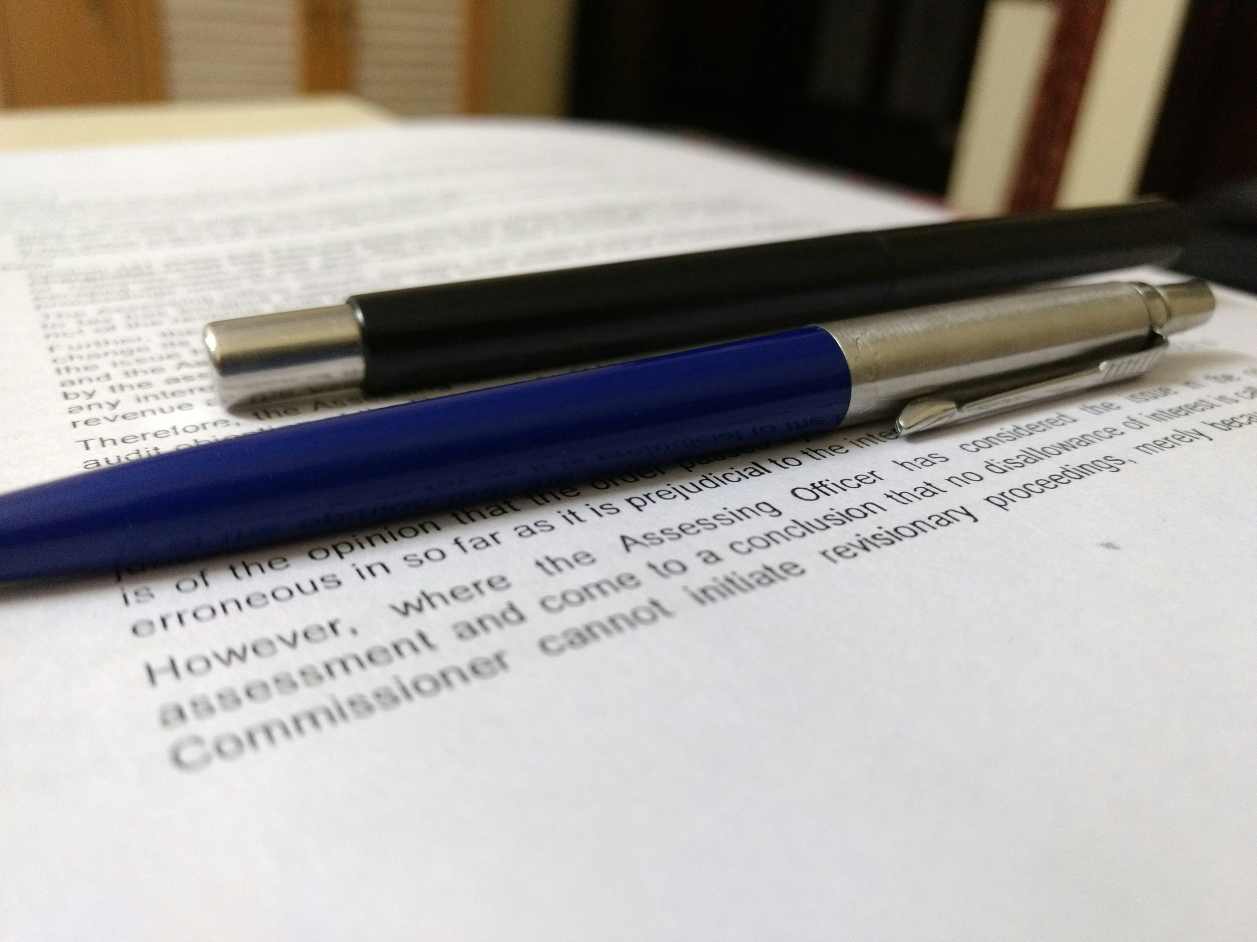 Two pens resting on a legal document, symbolizing written testimony, freedom of conscience, and accountability.